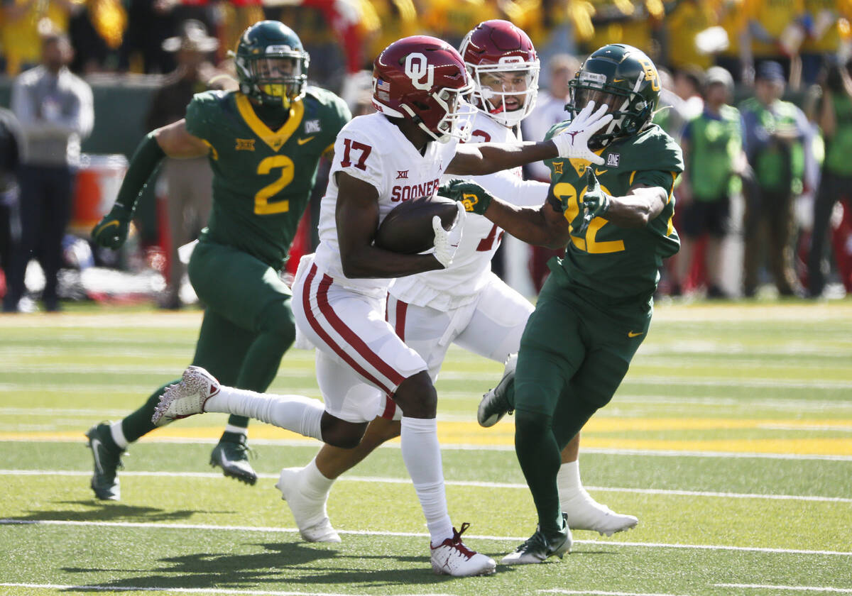 Oklahoma Sooners wide receiver Marvin Mims (17) makes his way past Baylor Bears safety JT Woods ...