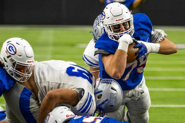 Bishop Gorman fullback Jake Taylor (79) dives into the end zone over McQueen defensive lineman ...