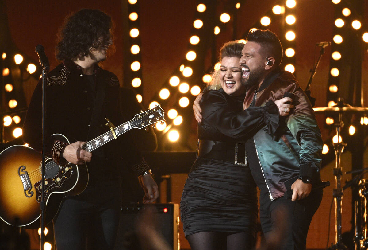 Dan Smyers, left, and Shay Mooney, right, of Dan + Shay, and Kelly Clarkson react after perform ...