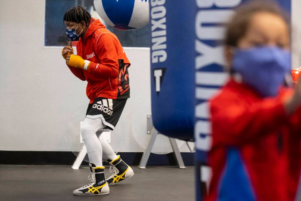 Shawn Porter, left, with his son Shaddai, 3, in the foreground, works out in preparation for an ...