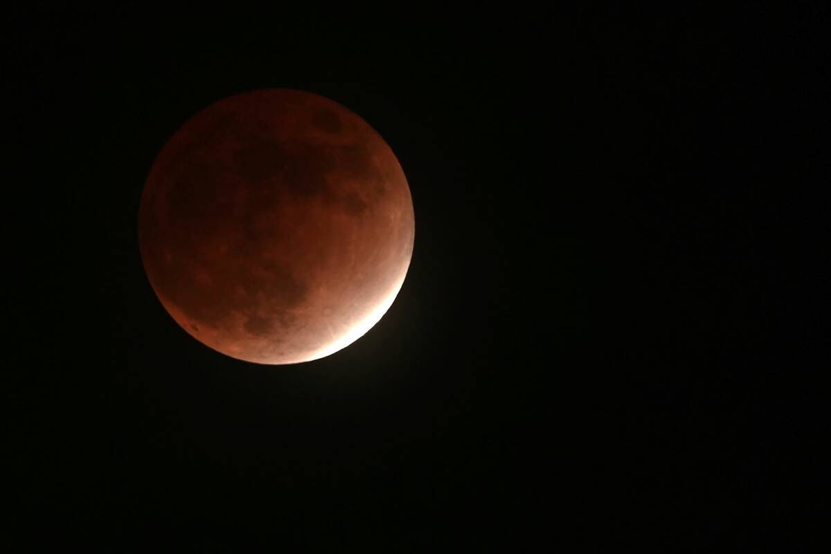 The earth's shadow covers the moon during a partial lunar eclipse Friday, Nov. 19, 2021, in Yok ...