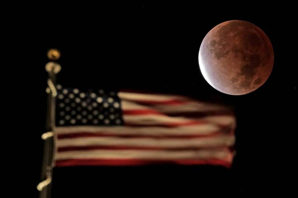 The earth's shadow covers the full moon during a partial lunar eclipse as it sets beyond the U. ...