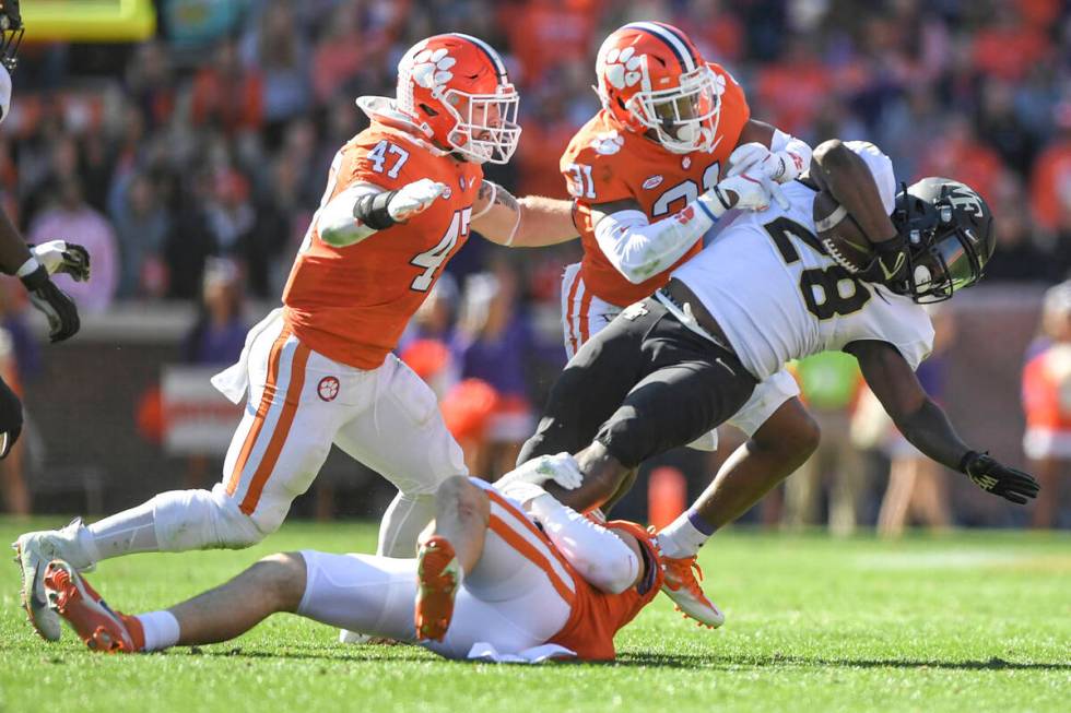 Clemson linebacker James Skalski(47) and cornerback Mario Goodrich (31) tackle Wake Forest runn ...