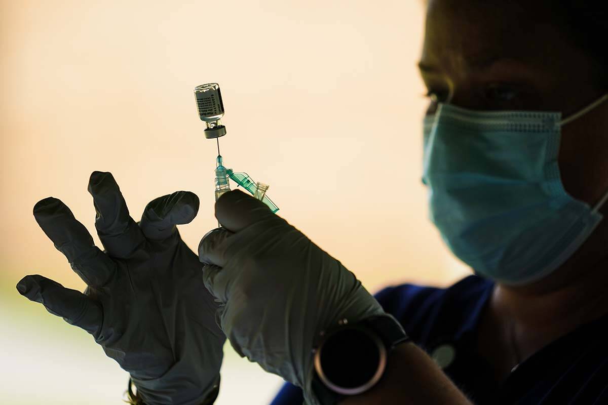 A syringe is prepared with the Pfizer COVID-19 vaccine at a clinic at the Reading Area Communit ...