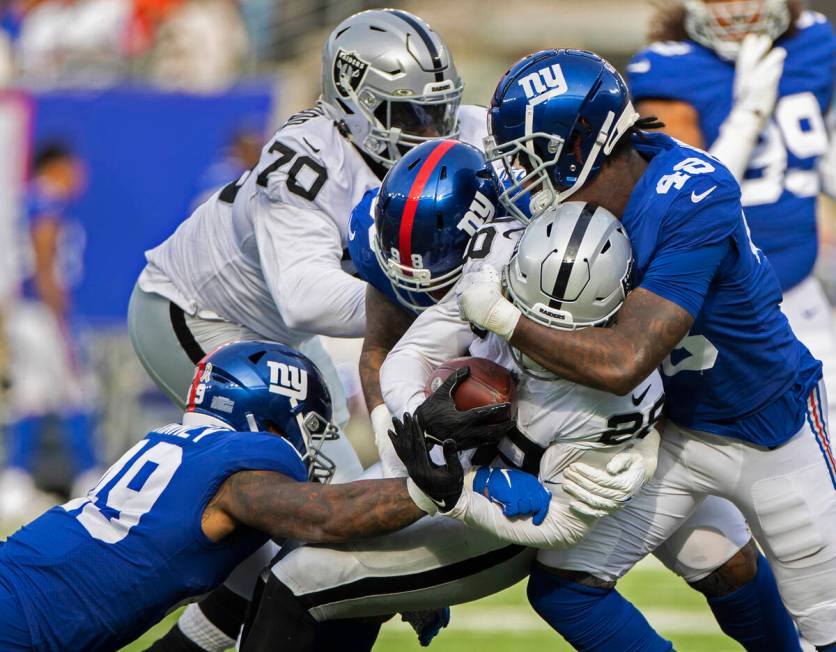 Las Vegas Raiders running back Josh Jacobs (28) is wrapped up by New York Giants linebacker Tae ...