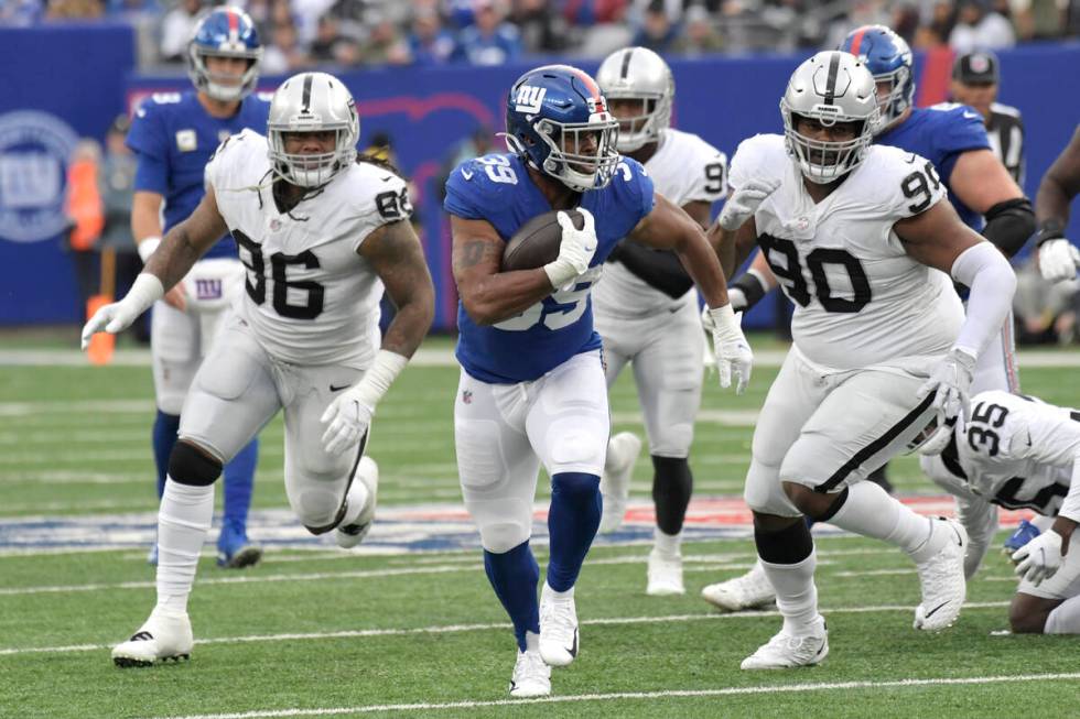 New York Giants running back Elijhaa Penny (39) is pursued by Las Vegas Raiders defensive tackl ...