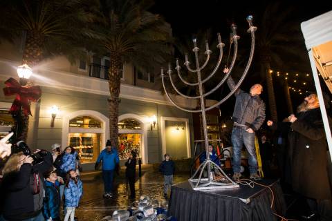 Arik Raiter lights the menorah for the second day of Hanukkah at an event hosted by the Chabad ...