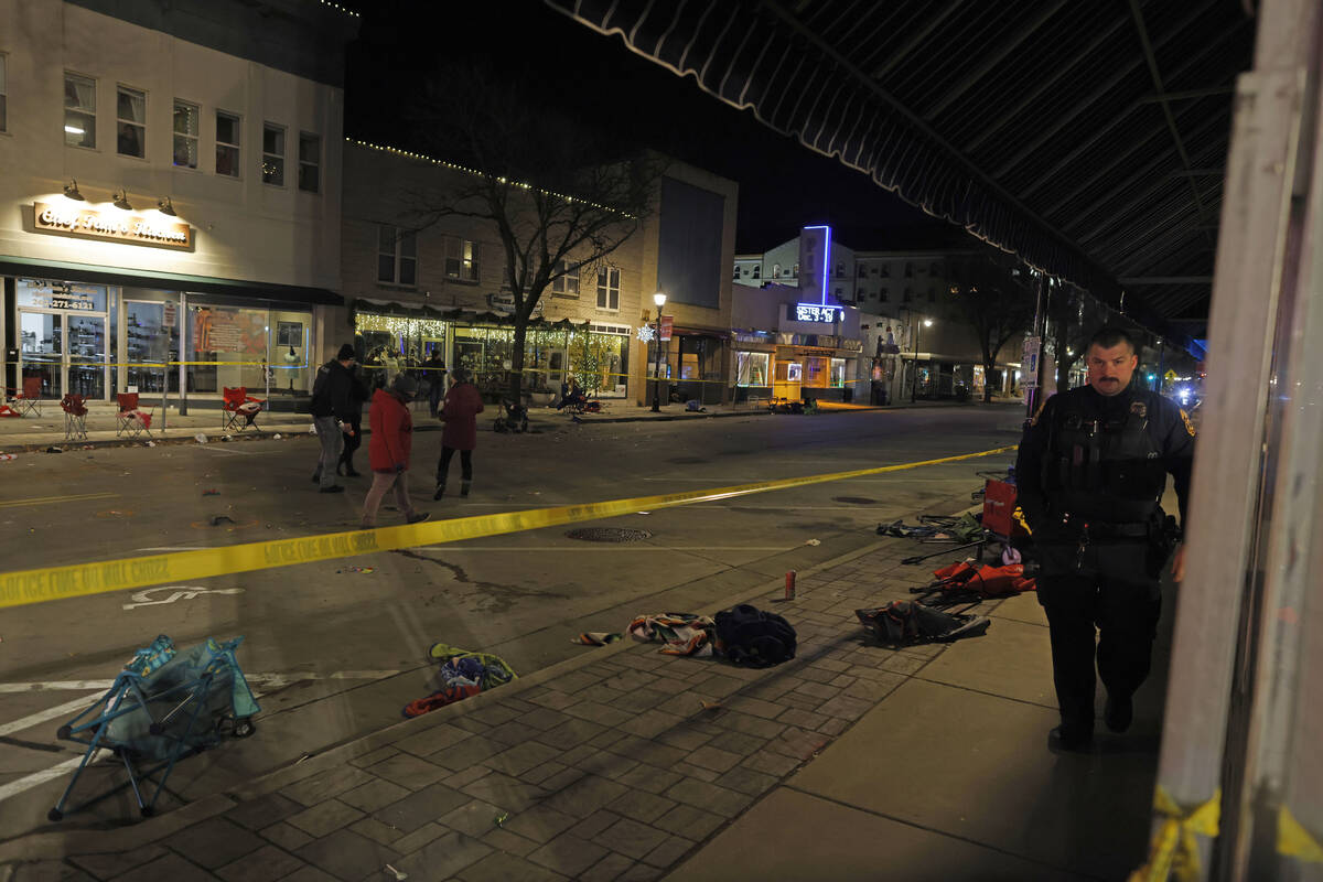 Police canvass the streets in downtown Waukesha, Wis., after a vehicle plowed into a Christmas ...