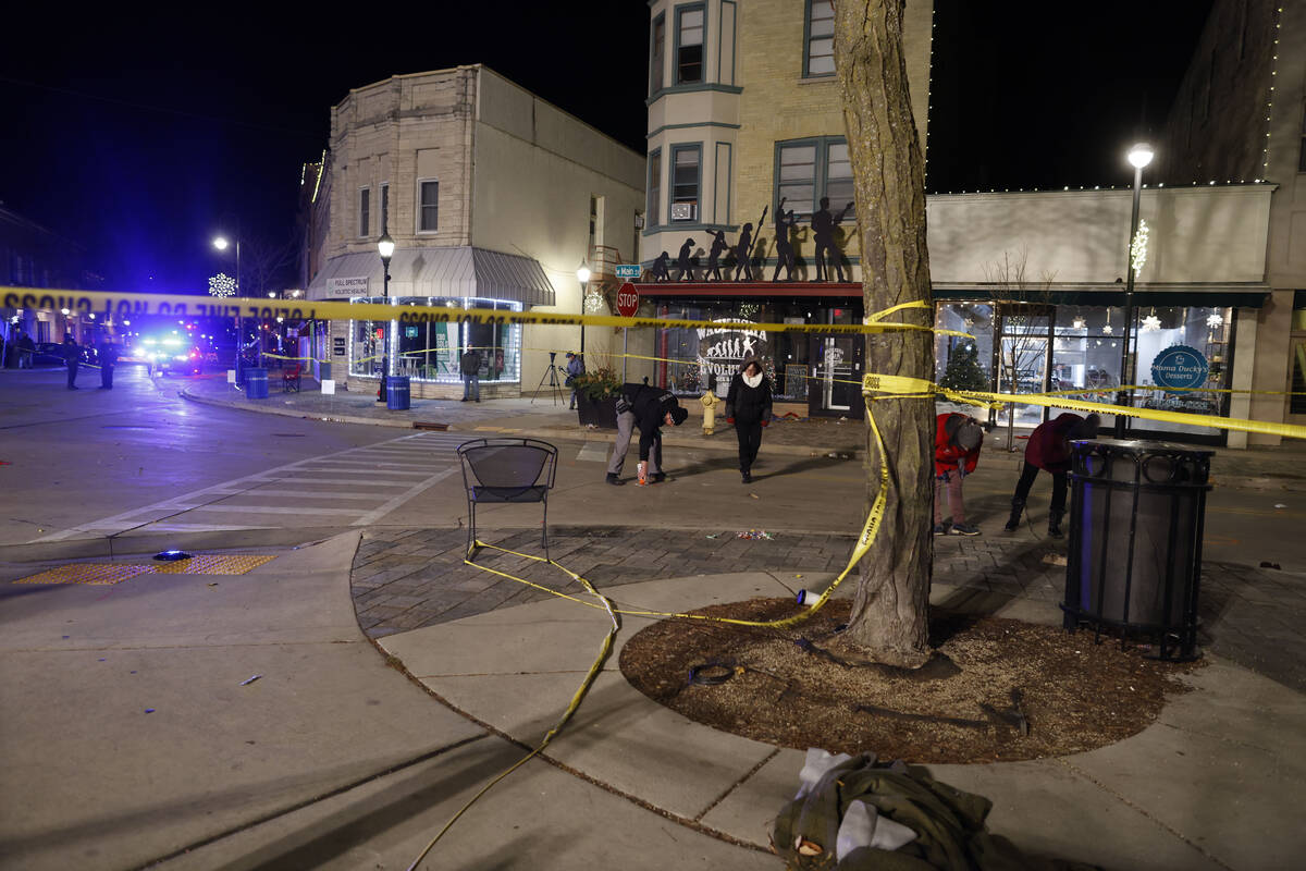 Police canvass the streets in downtown Waukesha, Wis., after a vehicle plowed into a Christmas ...