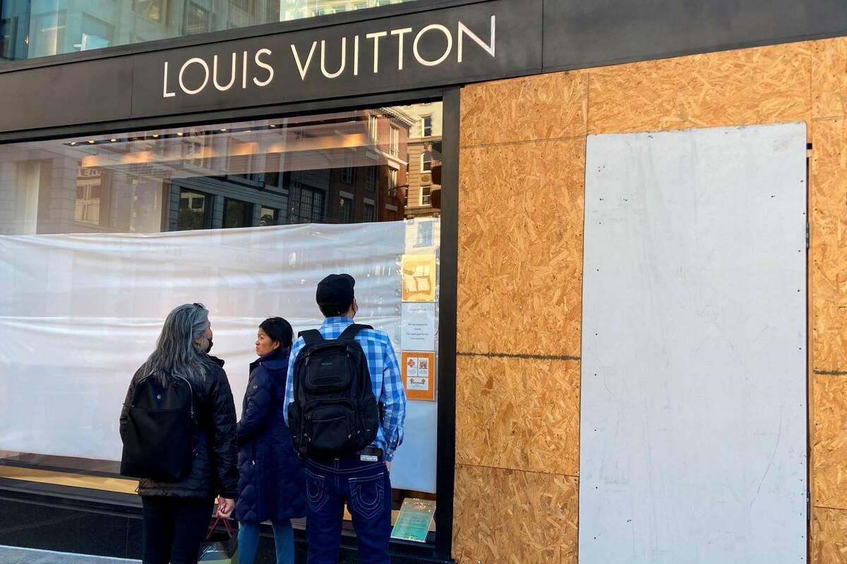 Union Square visitors look at damage to the Louis Vuitton store on Nov. 21, 2021, after looters ...