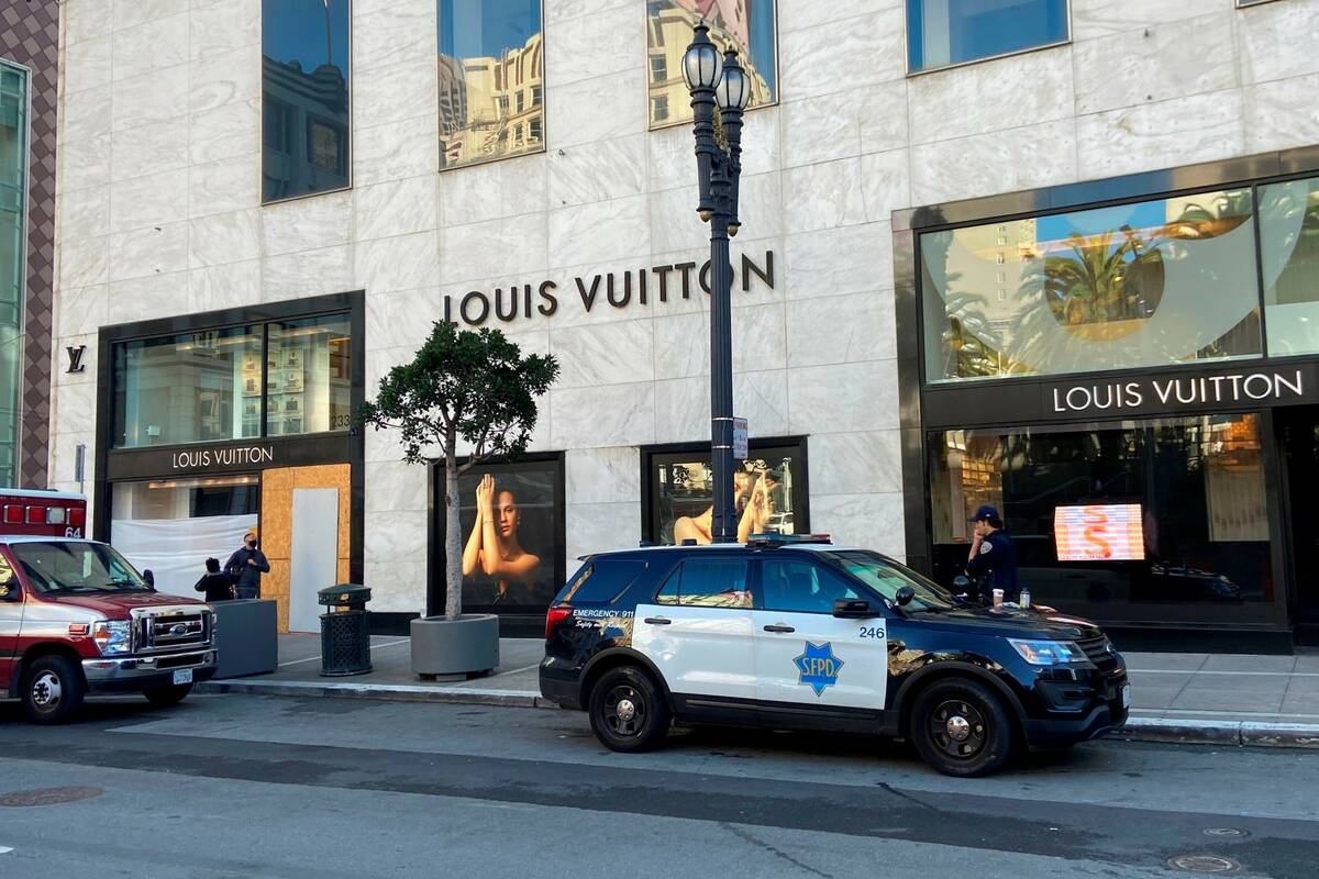 Police officers and emergency crews park outside the Louis Vuitton store in San Francisco's Uni ...