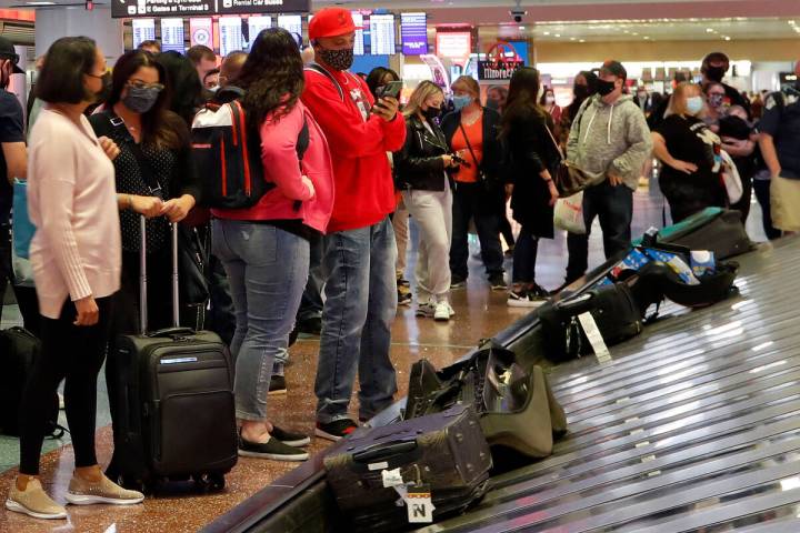 Arriving passengers await their bags in the baggage claim area of McCarran International Airpor ...