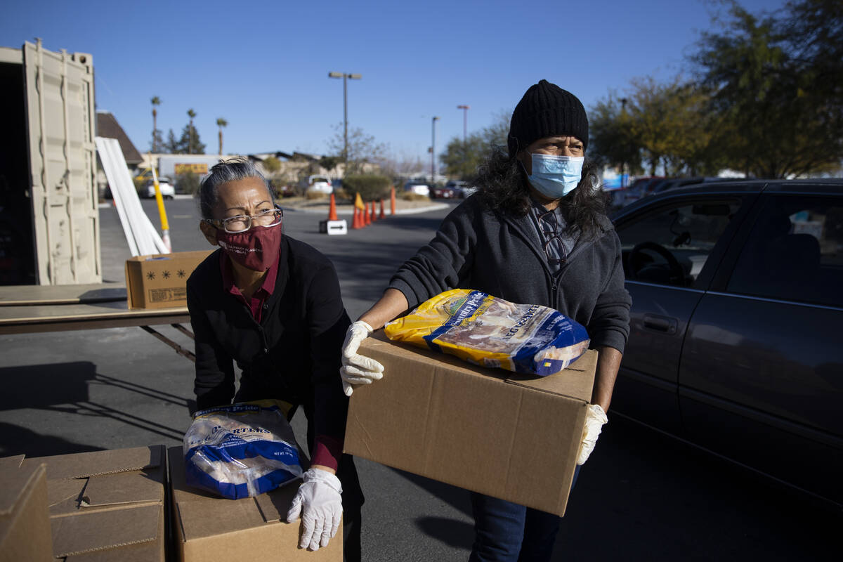 Rosa Escalante, left, and Vicenta Martinez, participate during a food distribution event at the ...