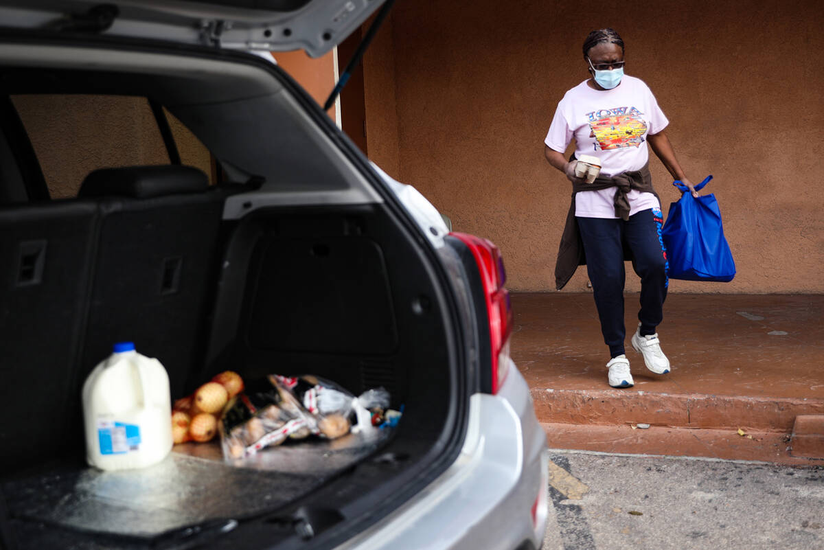 Volunteer Alma Smith carries food to her car to be delivered to senior citizens and people who ...