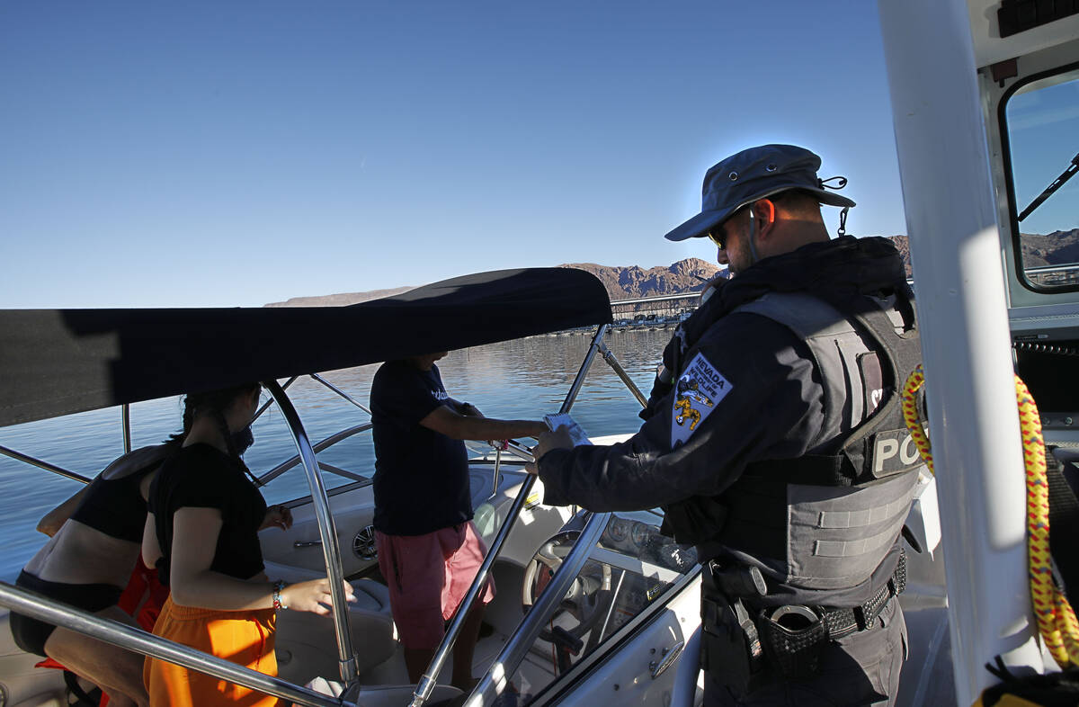 Sean Flynn, Nevada Department of Wildlife game warden, right, talks with boaters while he patro ...