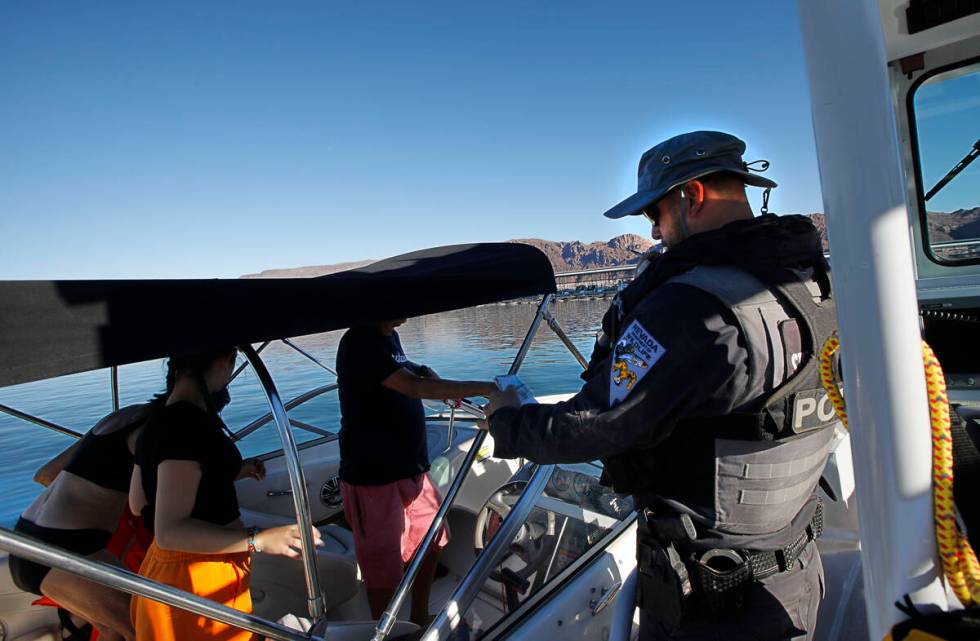 Sean Flynn, Nevada Department of Wildlife game warden, right, talks with boaters while he patro ...