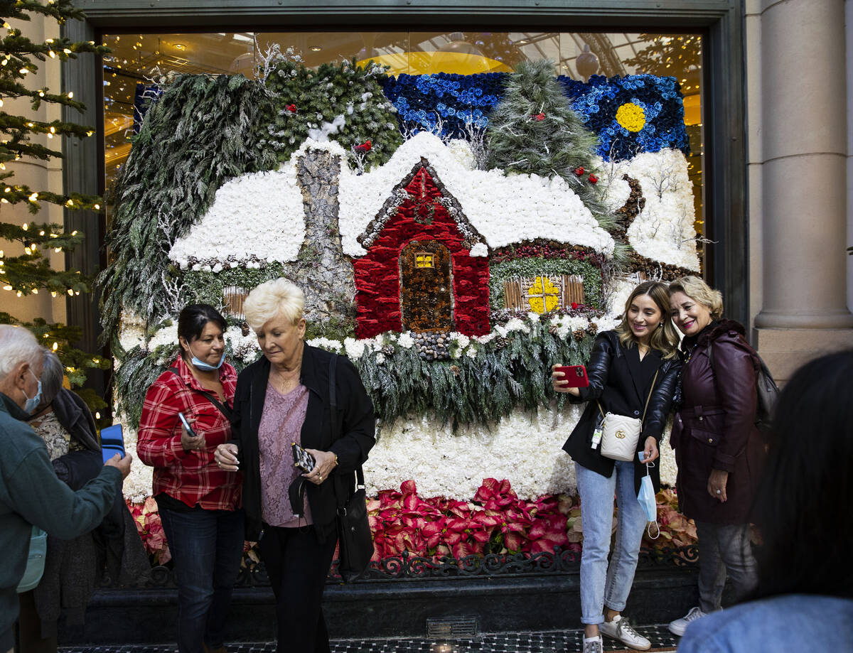 Tourists pose for a photo at The Bellagio Conservatory's holiday display "Holiday Time" on Tues ...