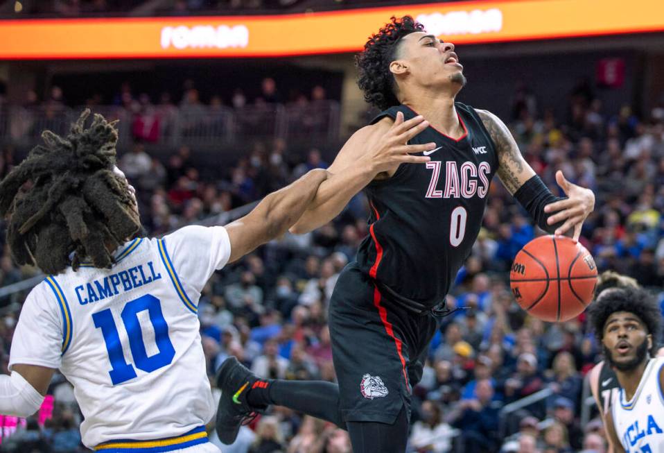 UCLA guard Tyger Campbell (10) fouls Gonzaga guard Julian Strawther (0) on a drive to the baske ...