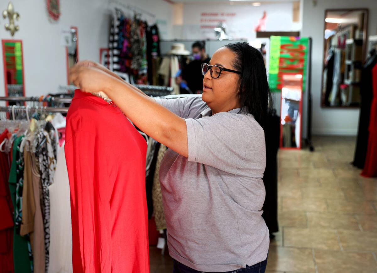 Vanessa Williams, a house manager with El Shaddai Refuge Homes, dresses a mannequin at Gems4U r ...