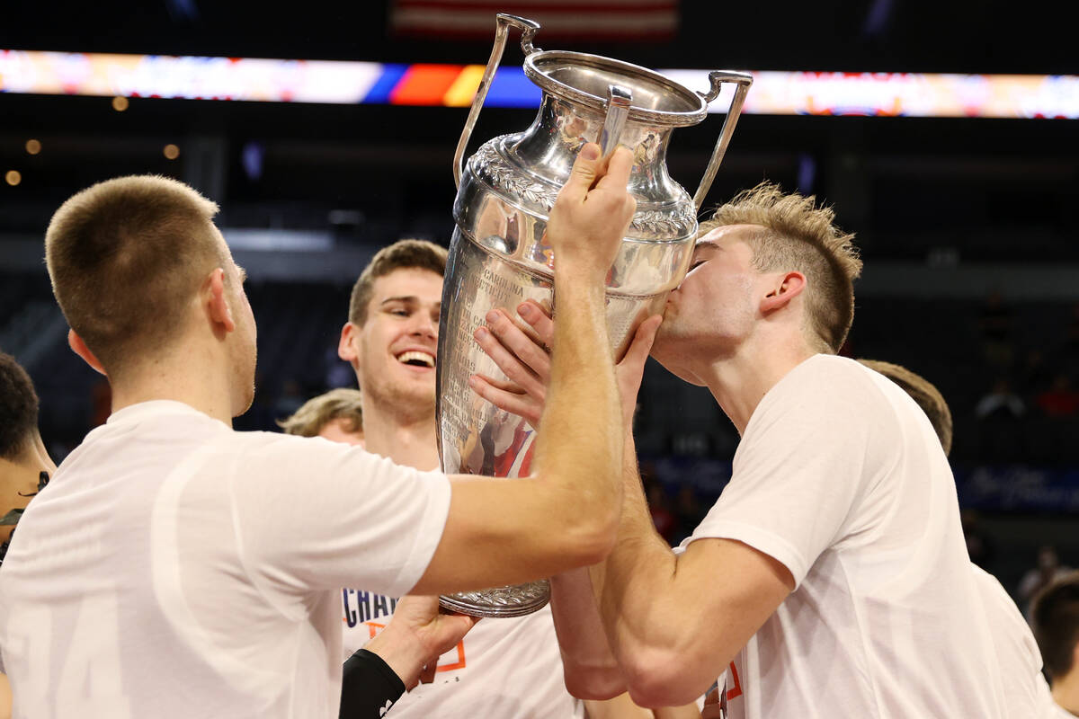 Wisconsin Badgers forward Tyler Wahl (5), right, kisses the trophy after a victory in the NCAA ...