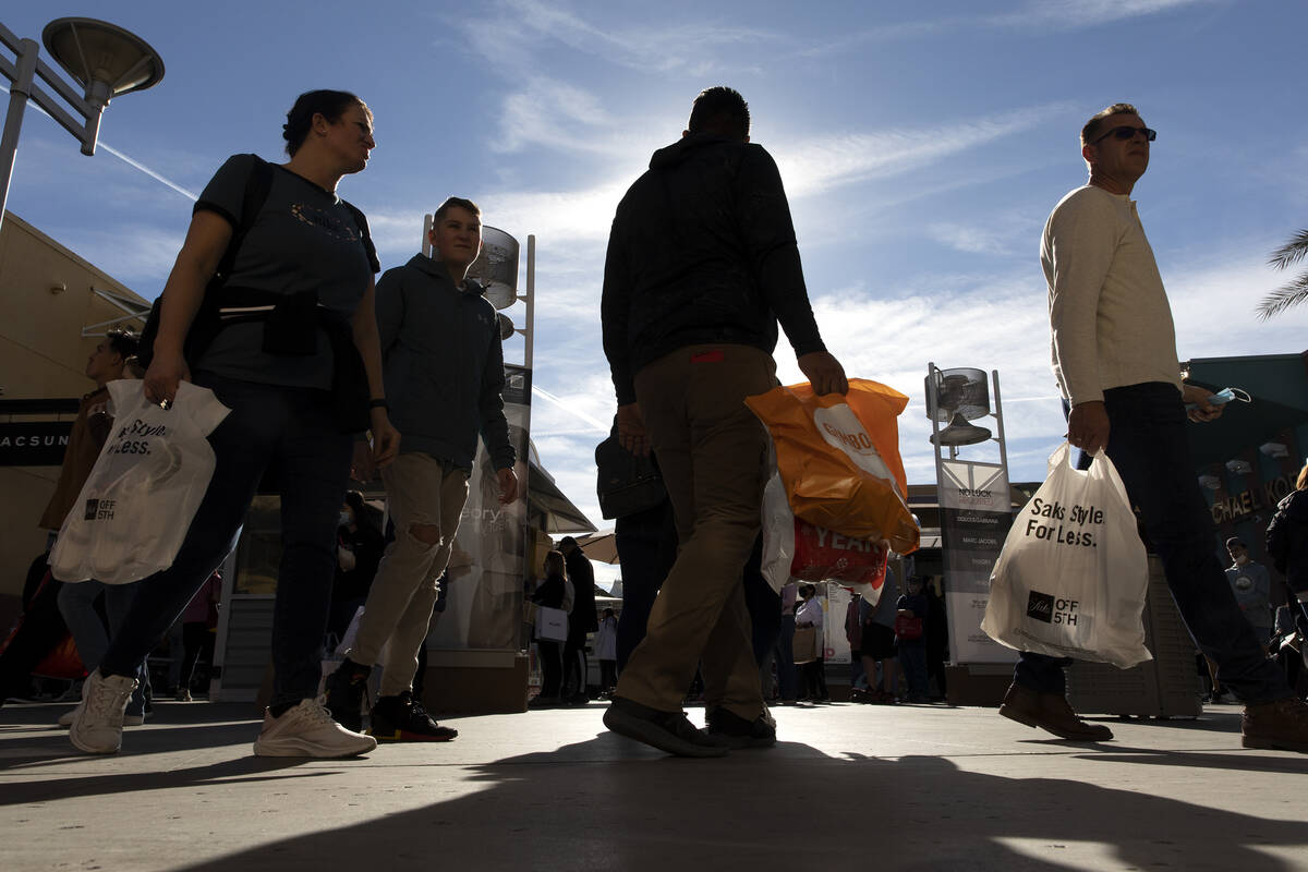 Customers carry their purchases during Black Friday shopping at the Las Vegas North Premium Out ...