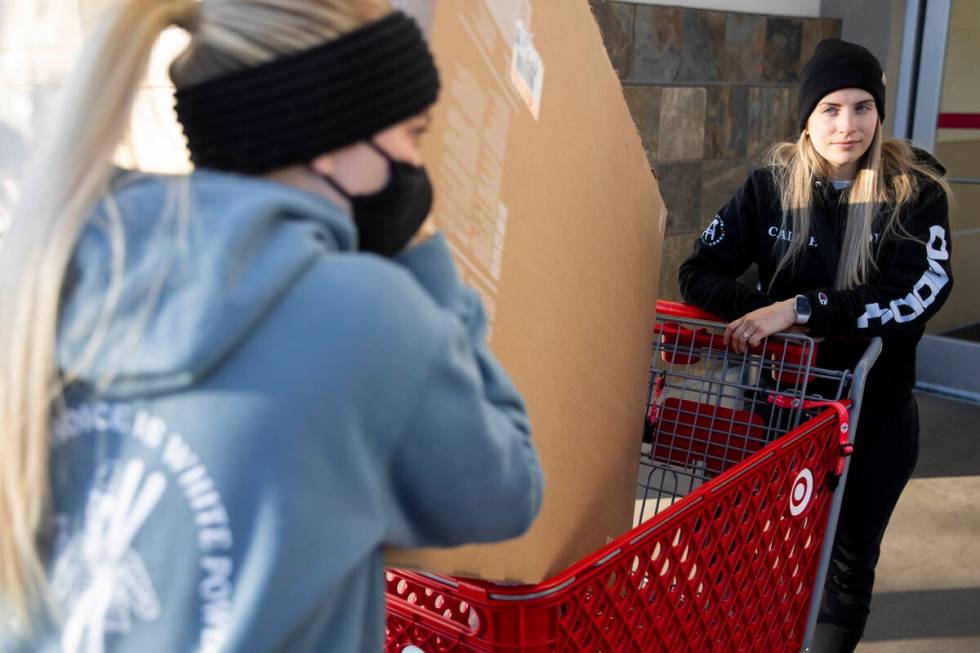Sam Zahn, left, and her fiancee Madison Bedor, push a cart with their new television after Blac ...
