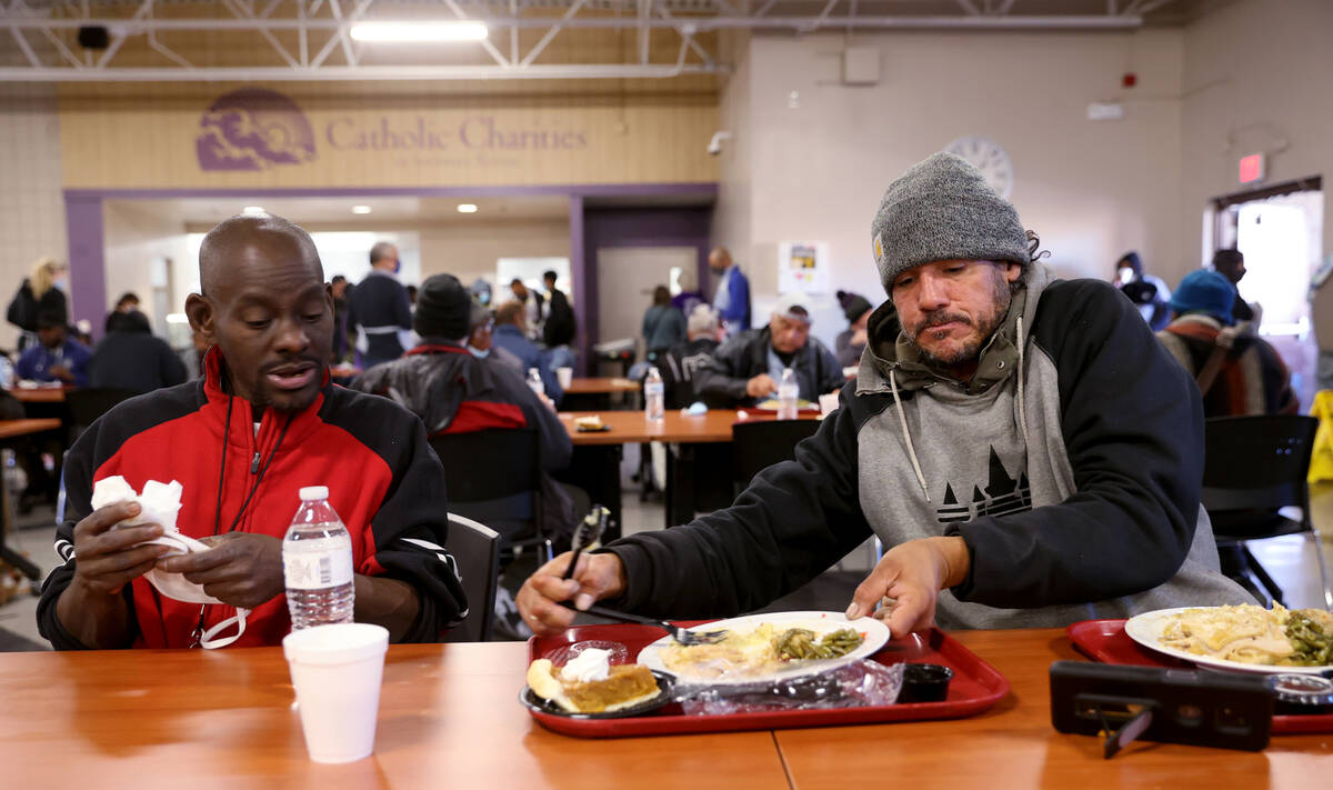 Ken Reed, 50, left, offers his plate to Michael Alvarado, 43, during a free Thanksgiving meal i ...