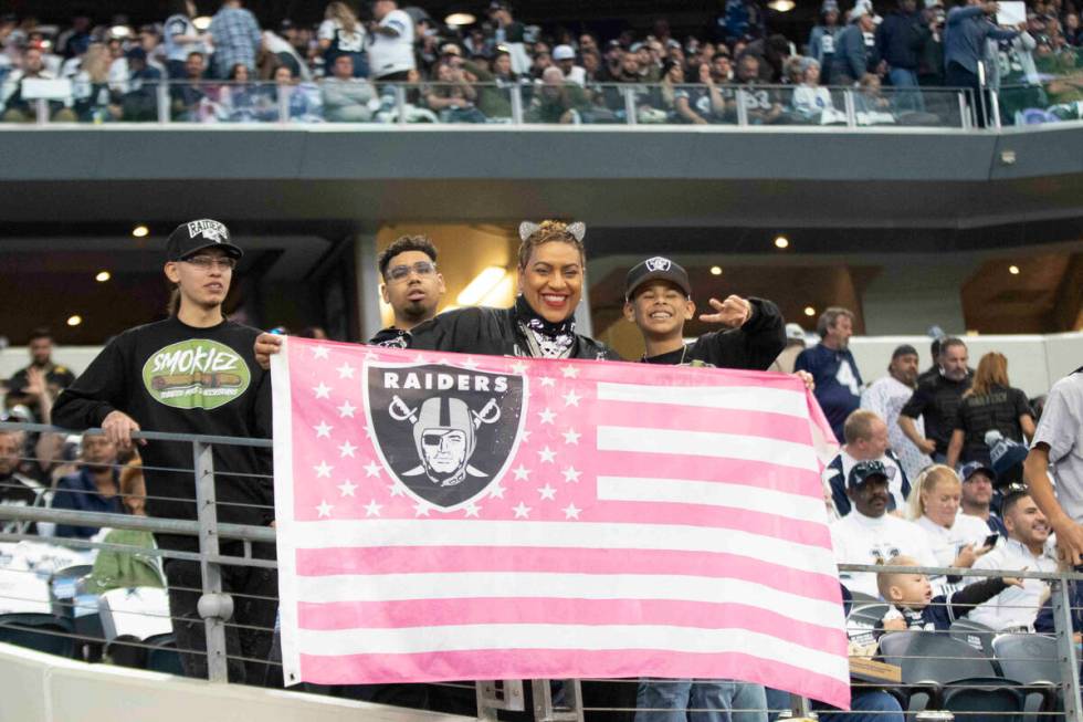 Raiders fans hold up a flag before an NFL football game against the Dallas Cowboys on Thursday, ...