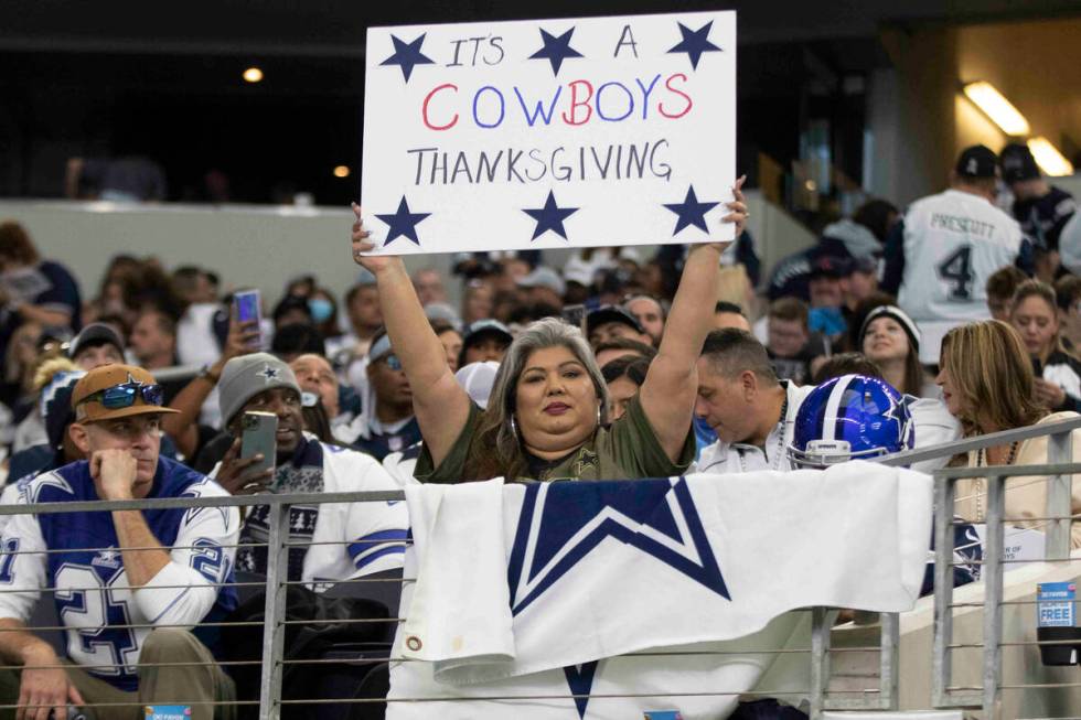 A Dallas Cowboys fan holds up a sign before an NFL football game against the Raiders on Thursda ...