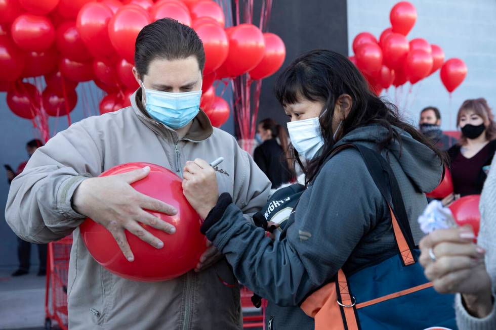 Dale Zalewski, left, and Sandra Zalewski write a message on a balloon during a vigil to the lat ...