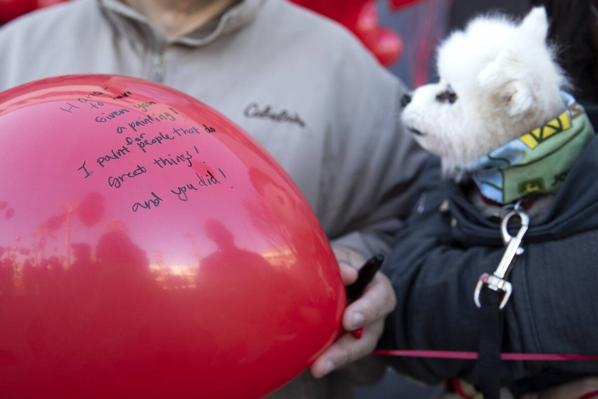 Dale Zalewski holds a balloon with a message from his wife, Sandra Zalewski, during a vigil to ...