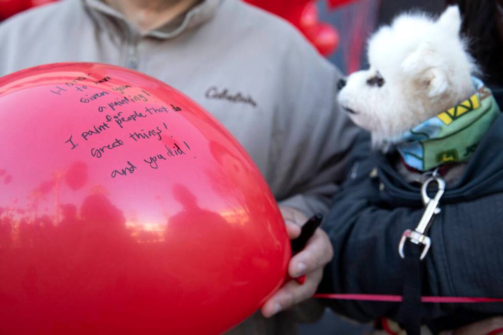 Dale Zalewski holds a balloon with a message from his wife, Sandra Zalewski, during a vigil to ...