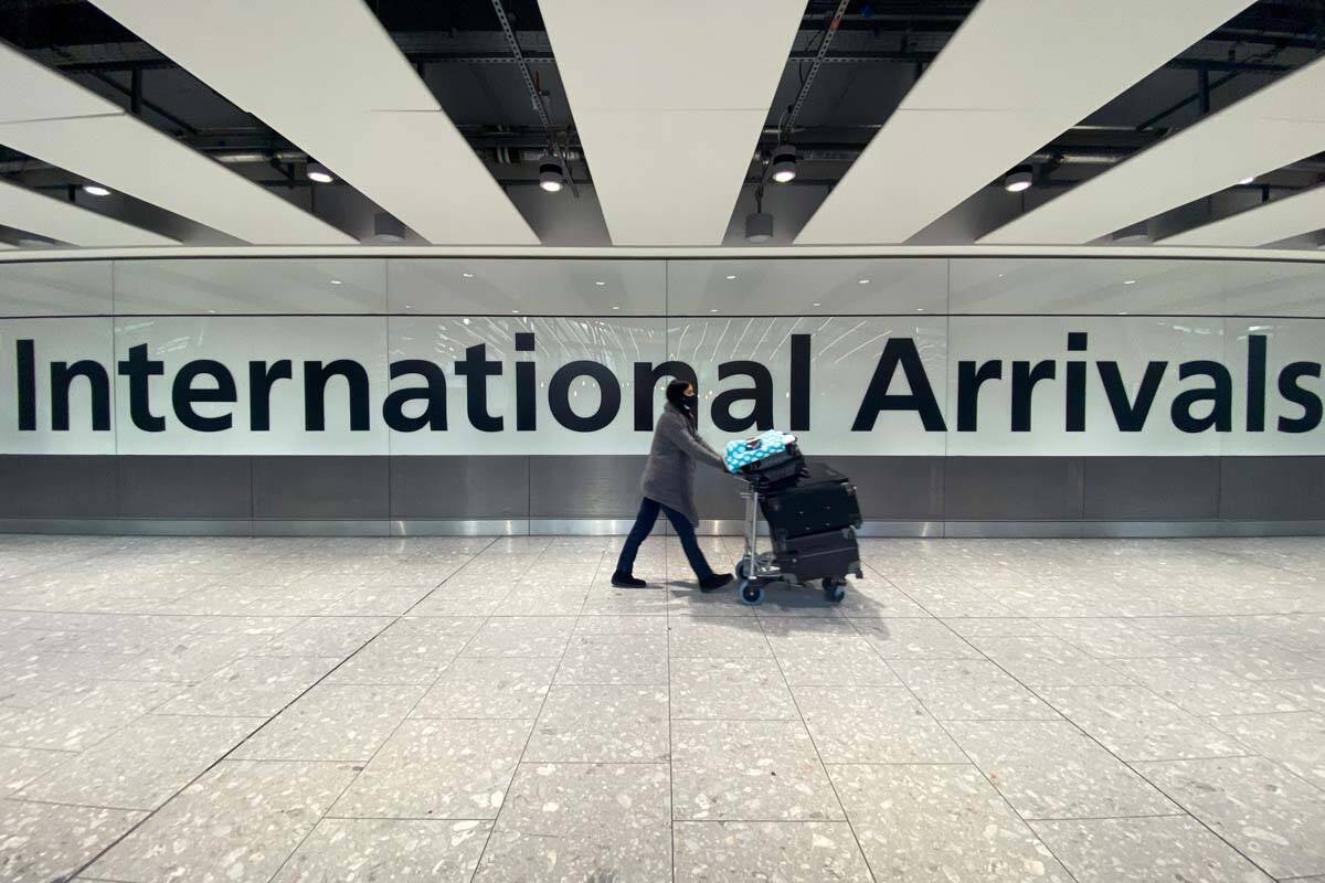 A passenger walks through International Arrivals, at London's Heathrow Airport, Friday, Nov. 26 ...