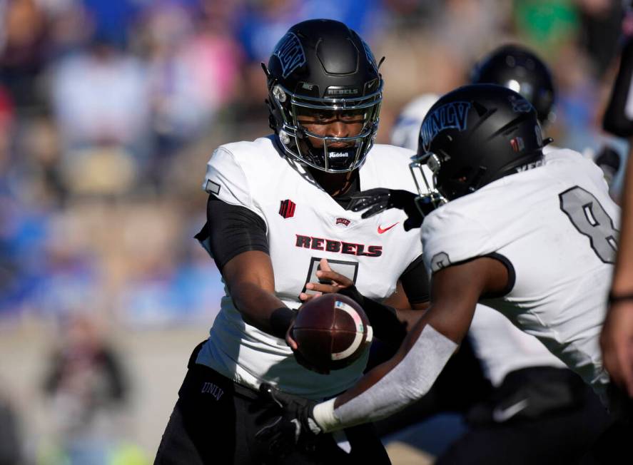 UNLV quarterback Justin Rogers, left, hands off the ball to running back Charles Williams in th ...