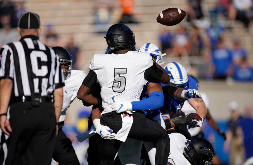 UNLV quarterback Justin Rogers (5) fumbles the ball as he is tackled by Air Force defensive tac ...