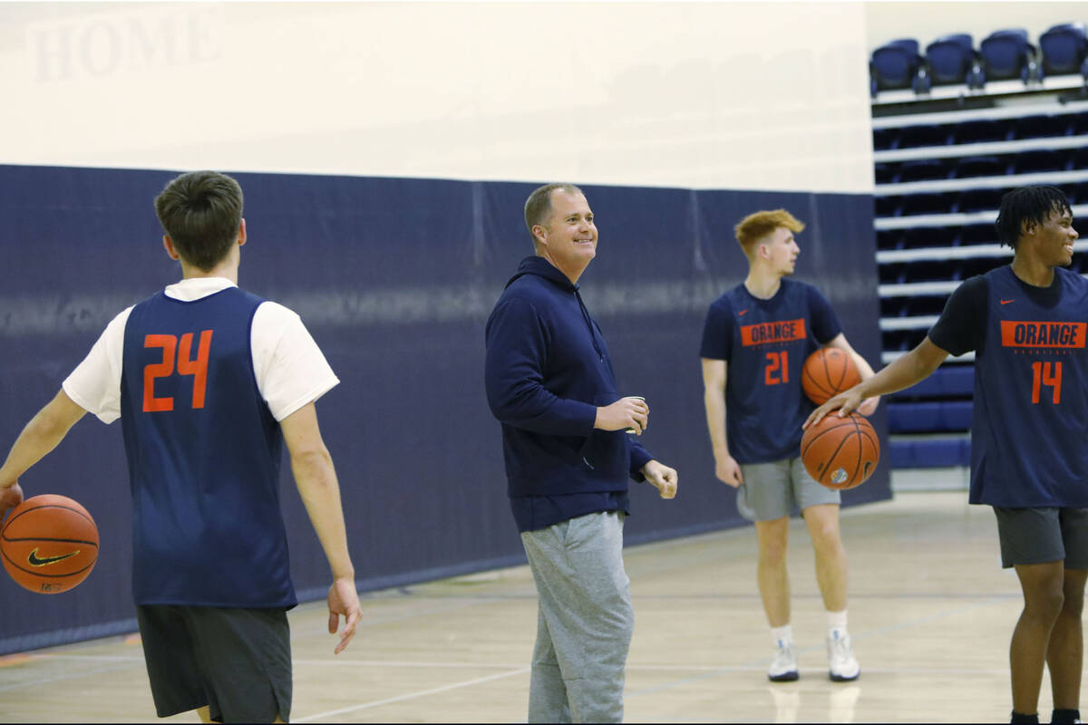 Bishop Gorman basketball head coach Grant Rice, center, smiles during a basketball practice at ...