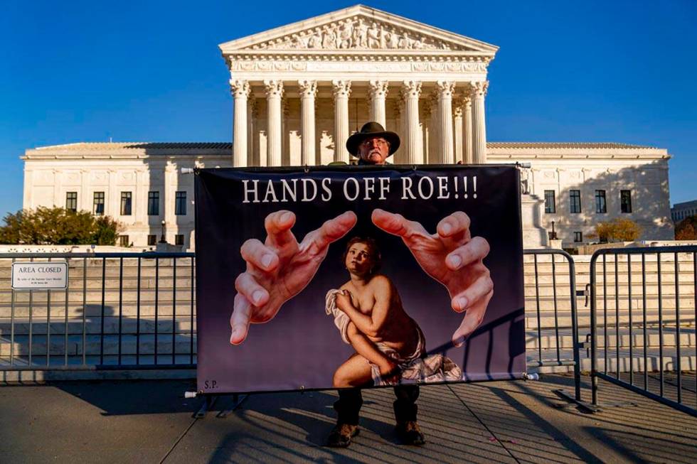 Stephen Parlato of Boulder, Colo., holds a sign that reads "Hands Off Roe!!!" outside ...