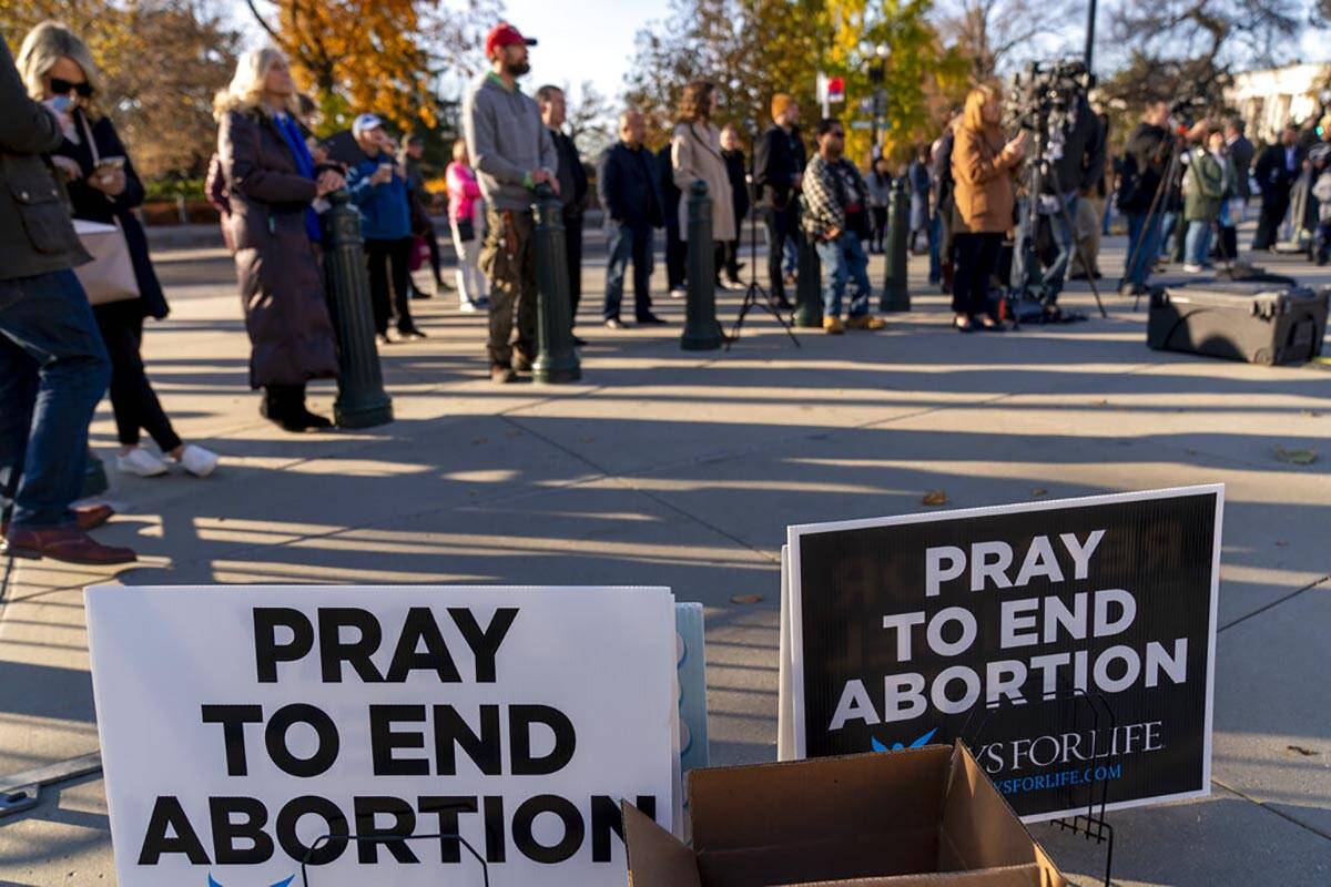 People listen during an anti-abortion rally outside of the Supreme Court in Washington, Tuesday ...