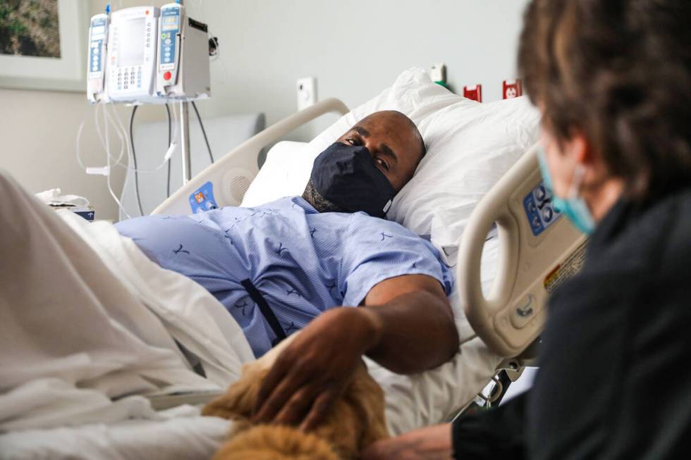 Wes Wallace, of Virginia, pets Lois, a comfort dog, alongside her caretaker Jennifer Pollock, a ...