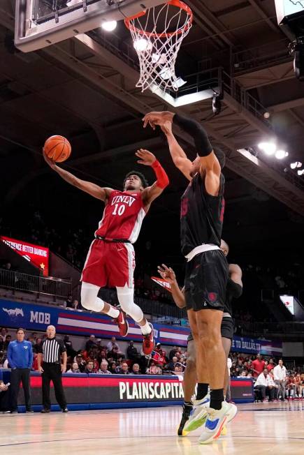 UNLV guard Keshon Gilbert (10) leaps to the basket for a shot as SMU's Tristan Clark, right, de ...