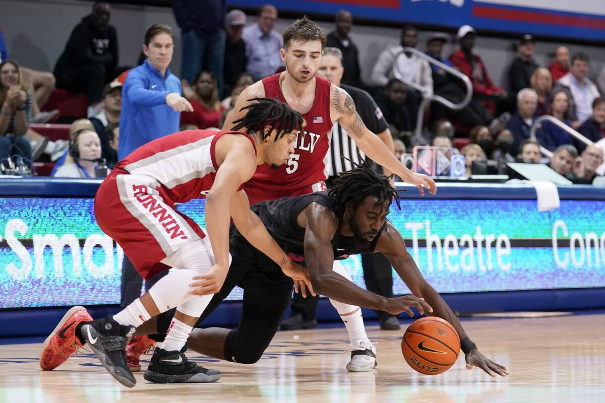 SMU guard Emmanuel Bandoumel dives to reach a loose ball in front of UNLV's Justin Webster, lef ...