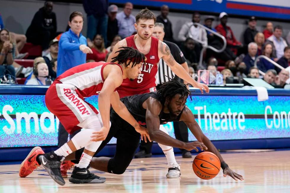 SMU guard Emmanuel Bandoumel dives to reach a loose ball in front of UNLV's Justin Webster, lef ...