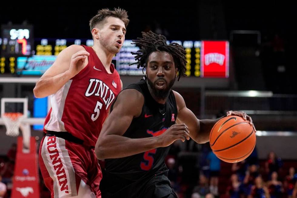 UNLV guard Jordan McCabe, left, defends as SMU guard Emmanuel Bandoumel, right, works to the ba ...