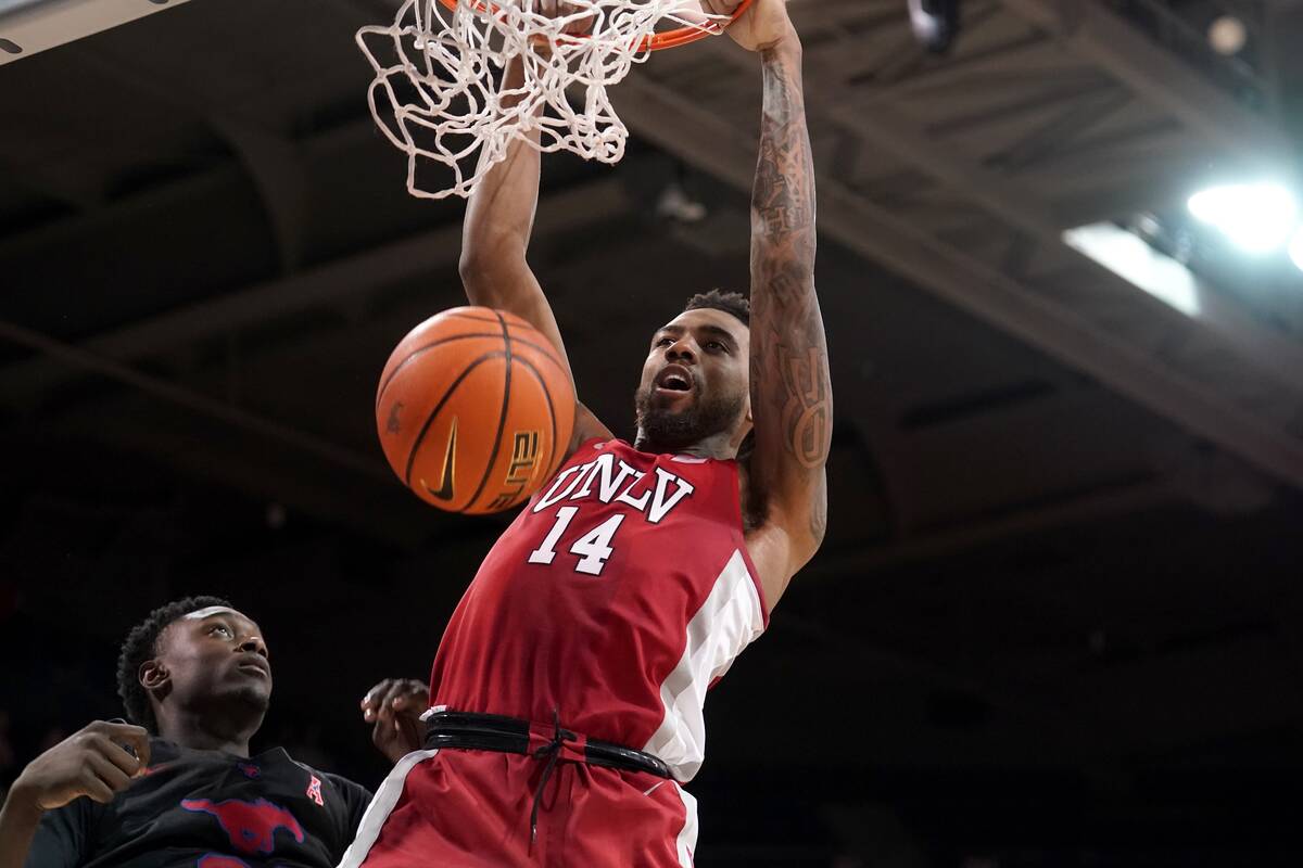 SMU forward Jahmar Young Jr., left, looks on as UNLV forward Royce Hamm Jr. (14) dunks in the f ...