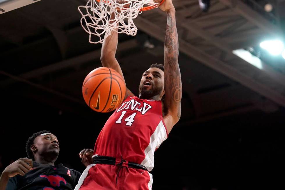 SMU forward Jahmar Young Jr., left, looks on as UNLV forward Royce Hamm Jr. (14) dunks in the f ...