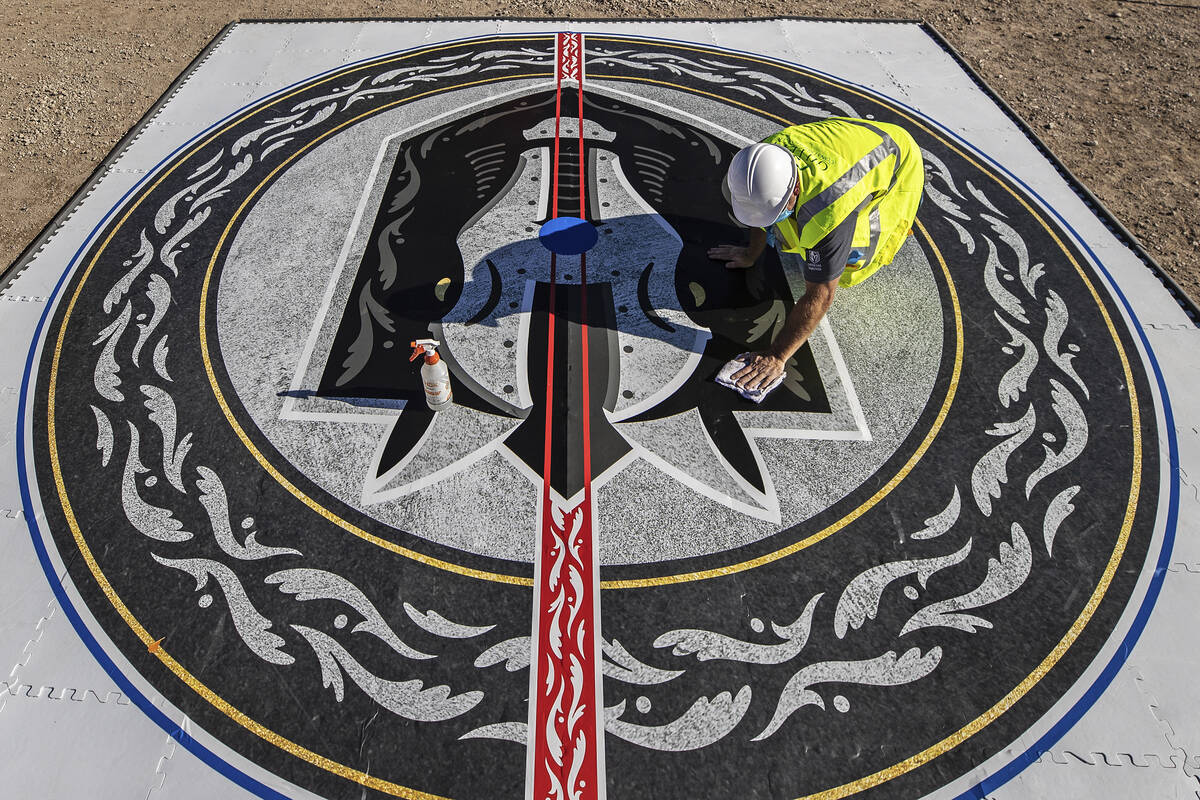 Construction workers put the finishing touches on the Henderson Silver Knights logo during a co ...