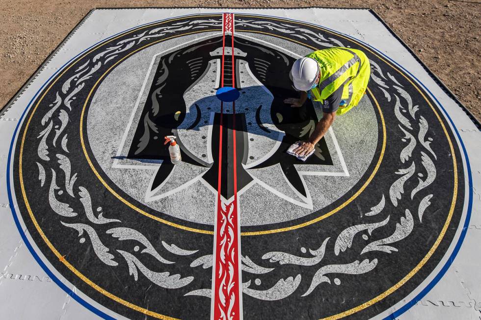 Construction workers put the finishing touches on the Henderson Silver Knights logo during a co ...