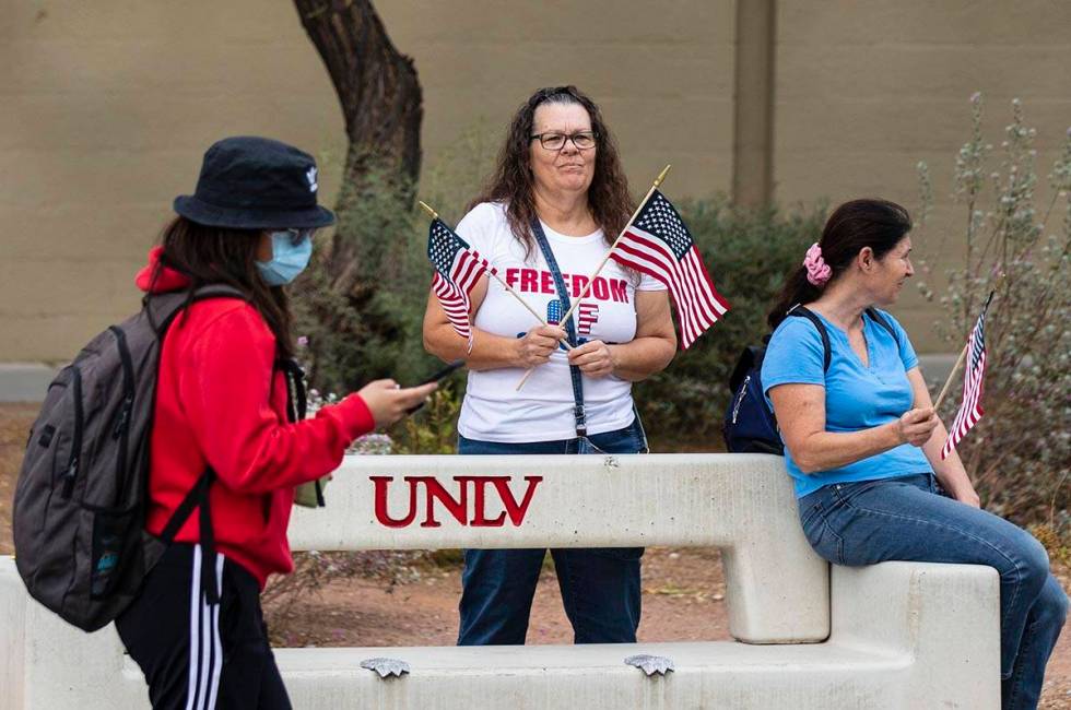 A UNLV student walks past protesters, including Susie K. of Las Vegas, right, as they protest a ...