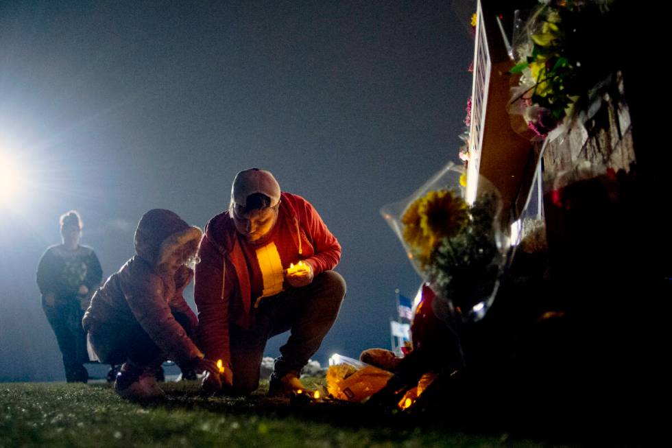 Waterford resident Andrew Baldwin, cousin of Madisyn Baldwin, places candles at the base of a a ...