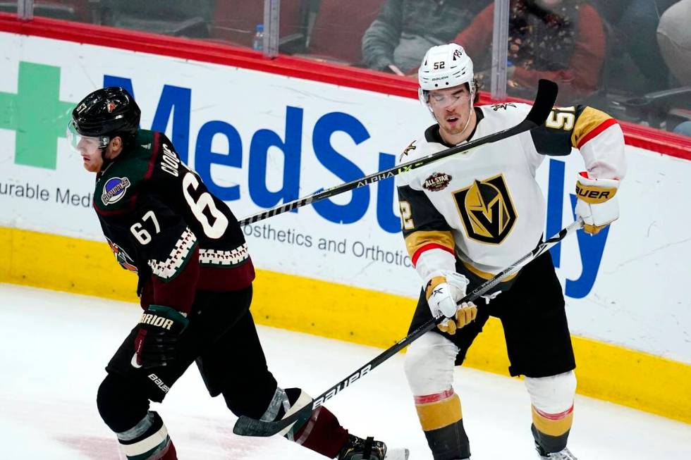 Arizona Coyotes left wing Lawson Crouse (67) catches Vegas Golden Knights defenseman Dylan Cogh ...